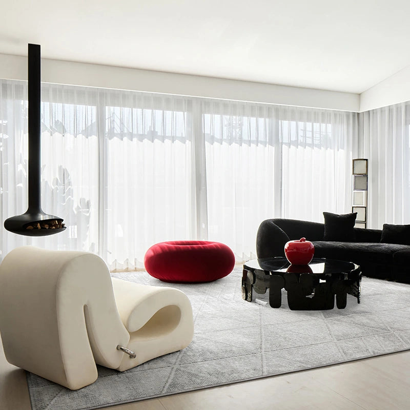 Modern luxury living room featuring a grey geometric-patterned rug, bold designer furniture, and contemporary decor with minimalist aesthetics
