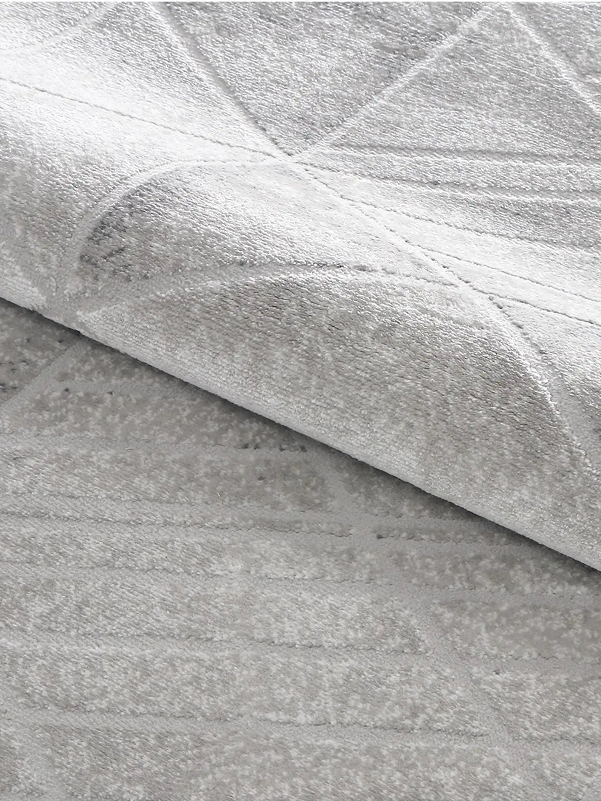 Close-up of grey geometric-patterned rug showcasing high-density weave, soft plush texture, and intricate craftsmanship