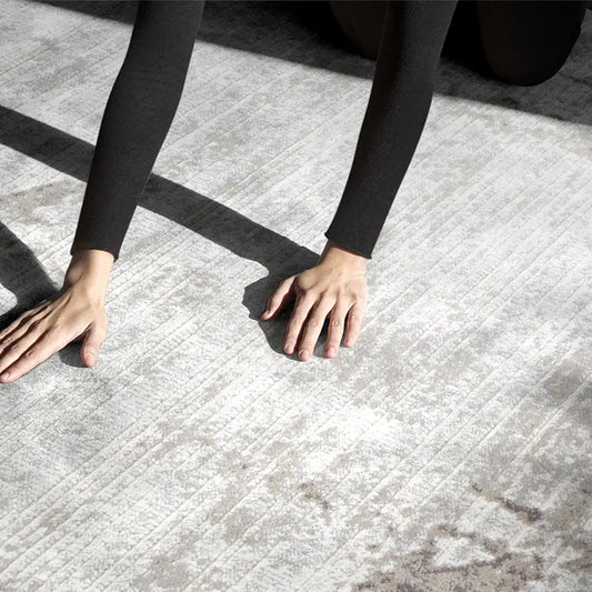 Close-up of hands touching a soft and luxurious abstract rug under natural sunlight #color_gray
