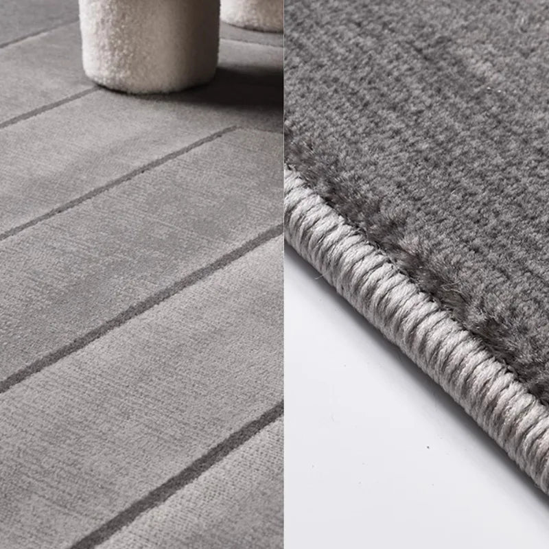 Close-up of high-low texture and reinforced double-stitched edges of a modern area rug, showcasing durability and intricate design