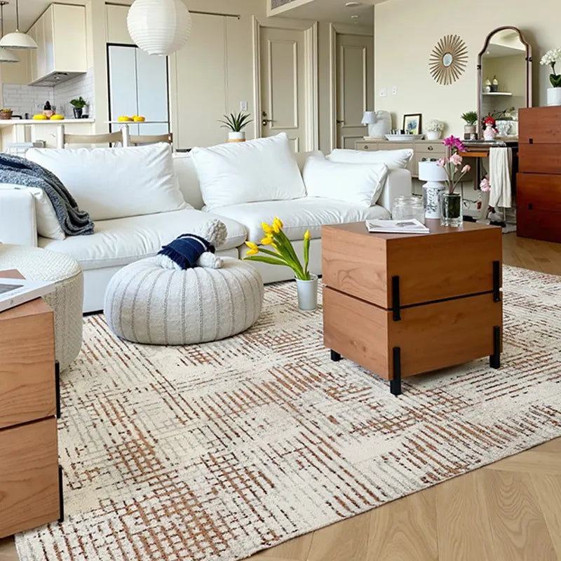 Italian modern geometric rug in a bright living room, styled with white sectional sofa, natural wood drawers, and cozy accents