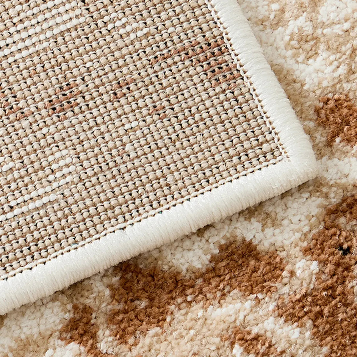 Back view of an ivory beige abstract area rug showing durable woven backing and reinforced edge finish