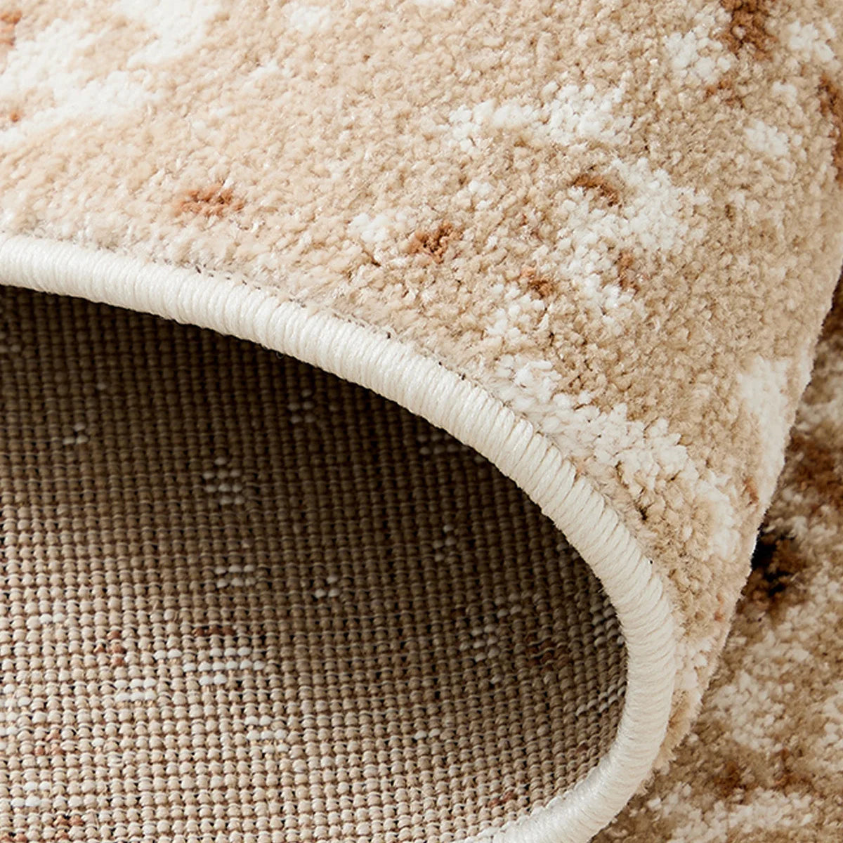 Close-up of reinforced edge binding on an ivory beige abstract area rug