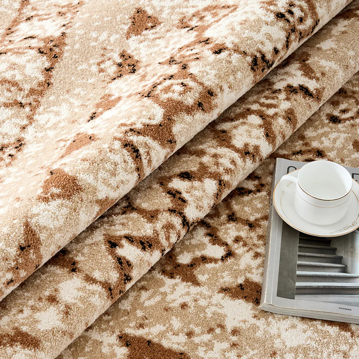 Ivory beige abstract area rug rolled up to show soft pile and flexible construction