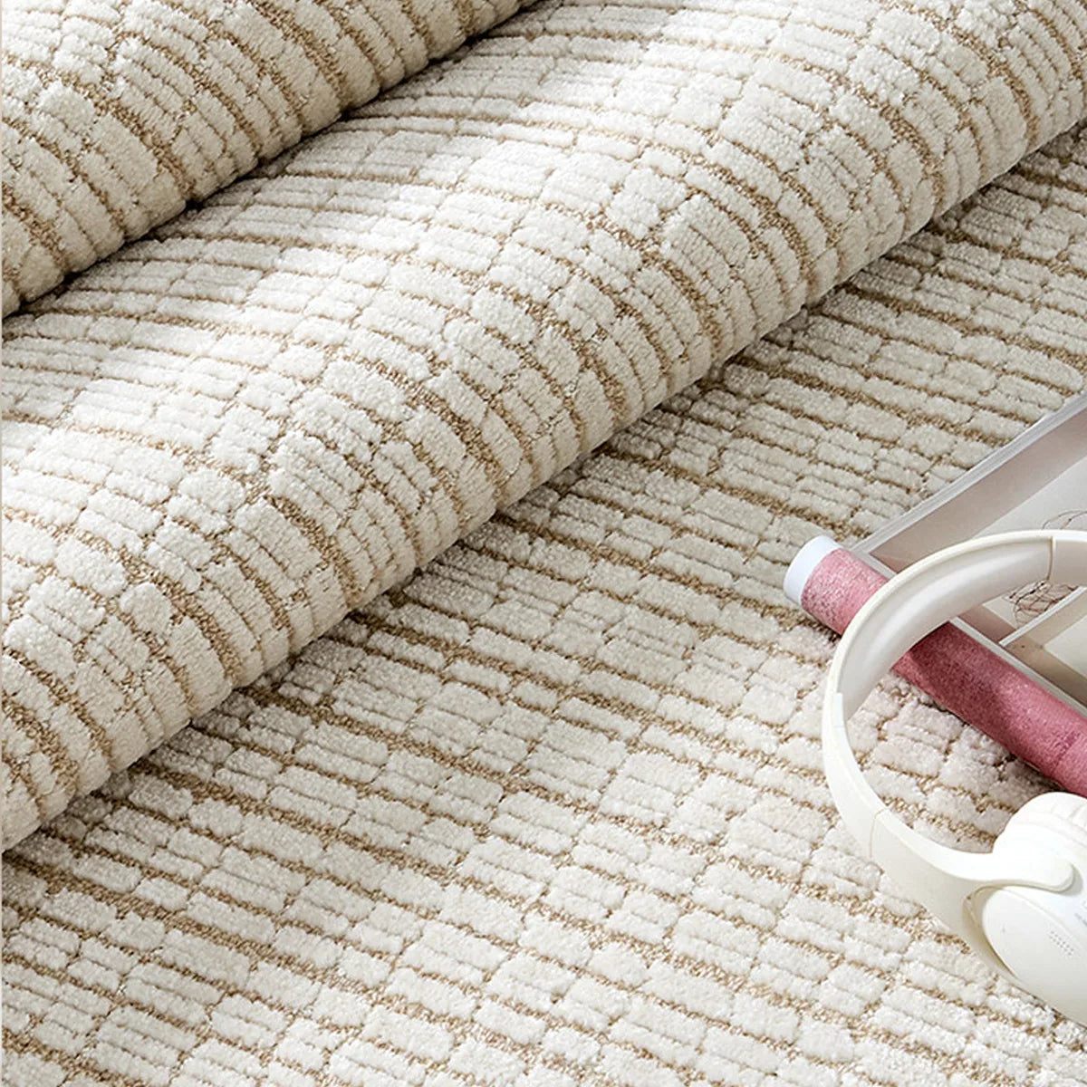 Rolled close-up of a cream beige grid wool blend area rug showing raised high-low cut-and-loop texture