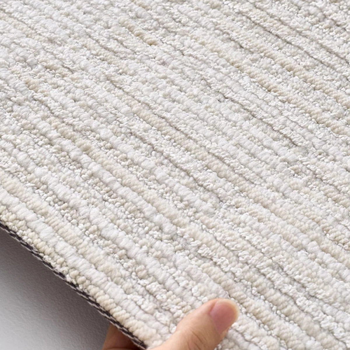 Ivory gray linear textured area rug edge detail showing dense woven construction and low pile surface