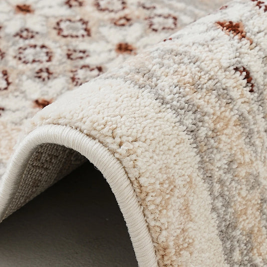 Ivory gray rust vintage area rug edge detail showing soft pile texture and finished binding