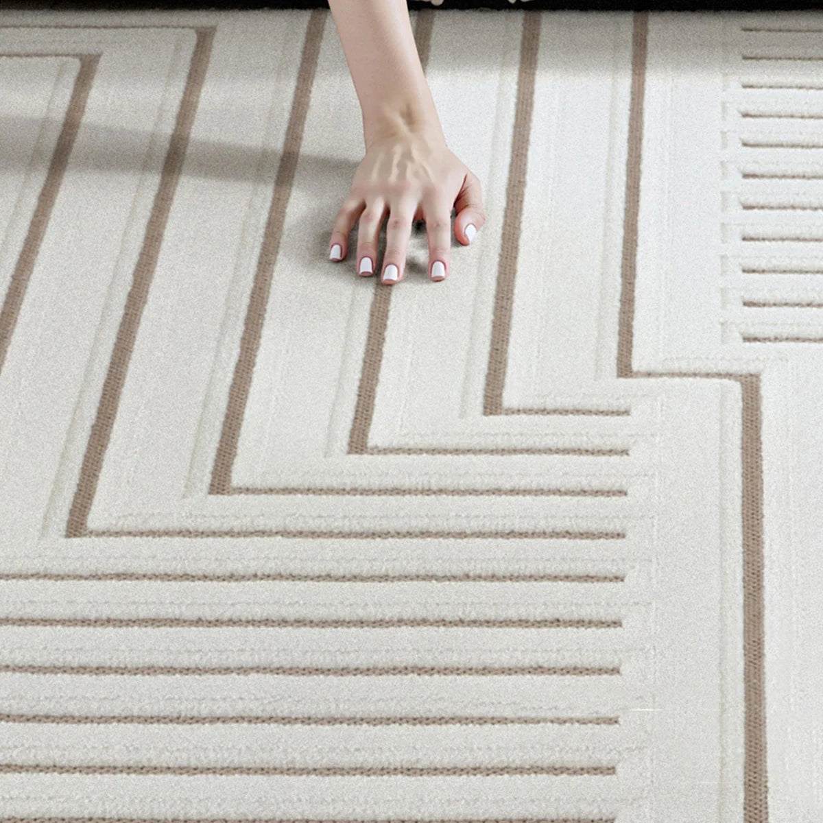 Ivory taupe geometric line rug with raised texture detail shown by hand