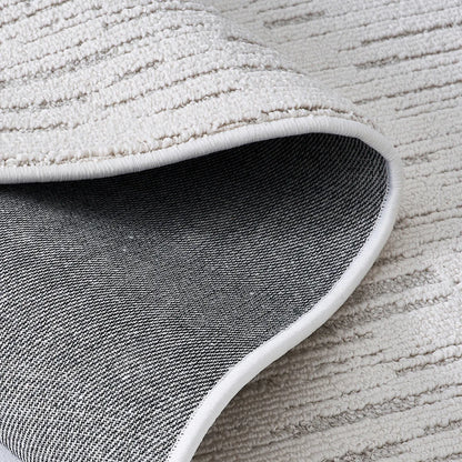 Back view of an ivory textured area rug showing durable woven backing and reinforced edge construction