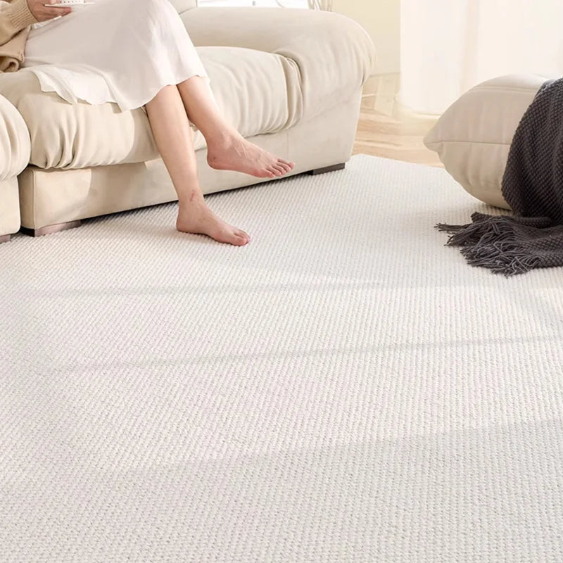 Ivory wool rug with soft texture and hand-tufted finish, placed in a cozy beige-toned living room