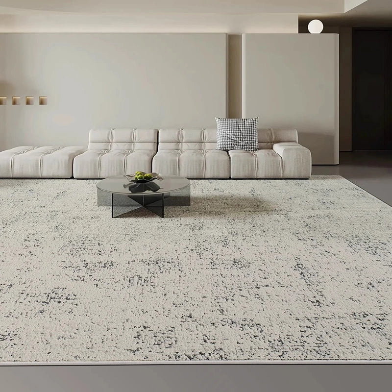 large gray area rug in a modern living room with minimalist sofa and open space layout