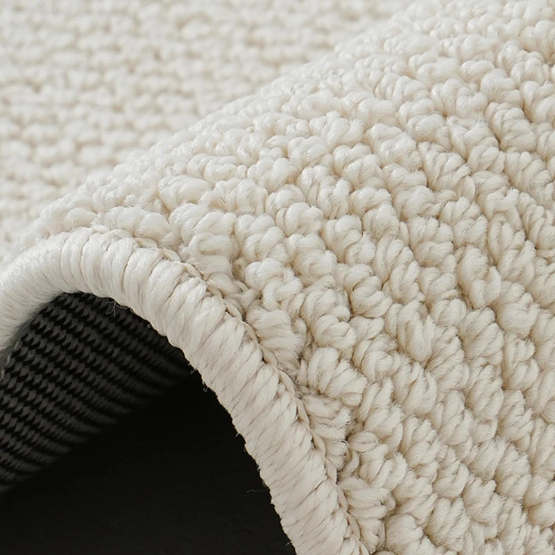 Close-up of loop pile wool rug showing textured surface and reinforced double-edge finish