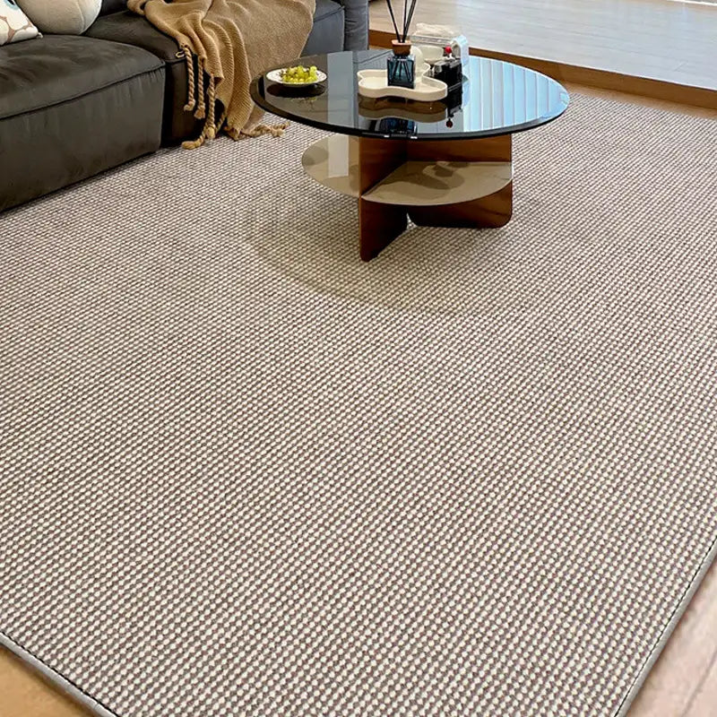 Wool blend loop pile rug in taupe and cream tones under modern round glass coffee table