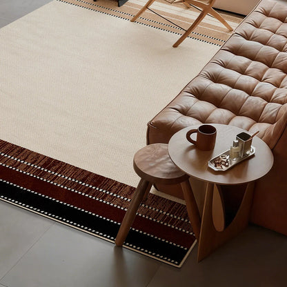 Cream beige border rug in a modern living room with a coffee table and warm brown striped edges