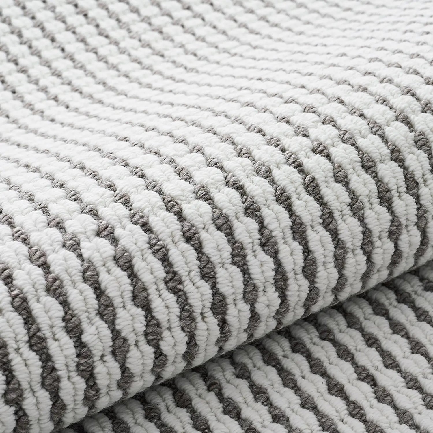 Close-up of minimalist woven rug texture in white and gray loop yarns