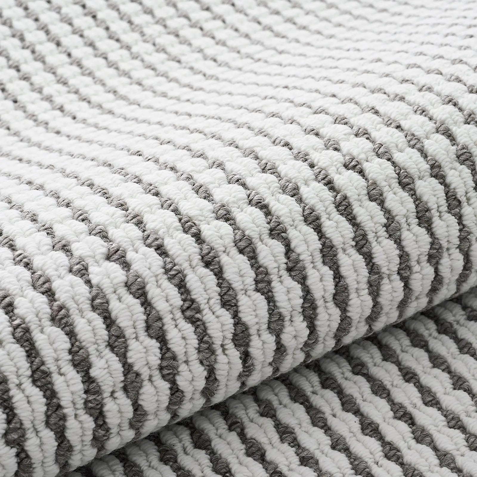 Close-up of minimalist woven rug texture in white and gray loop yarns