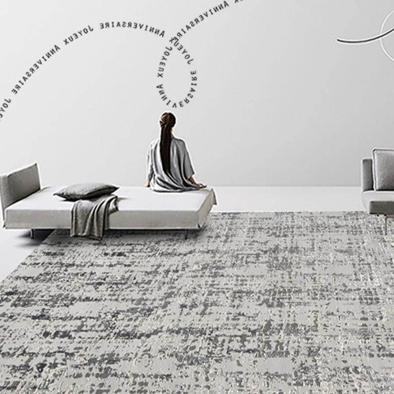 Minimalist room featuring a modern abstract gray rug with a woman meditating on a low-profile bed and clean, contemporary decor.