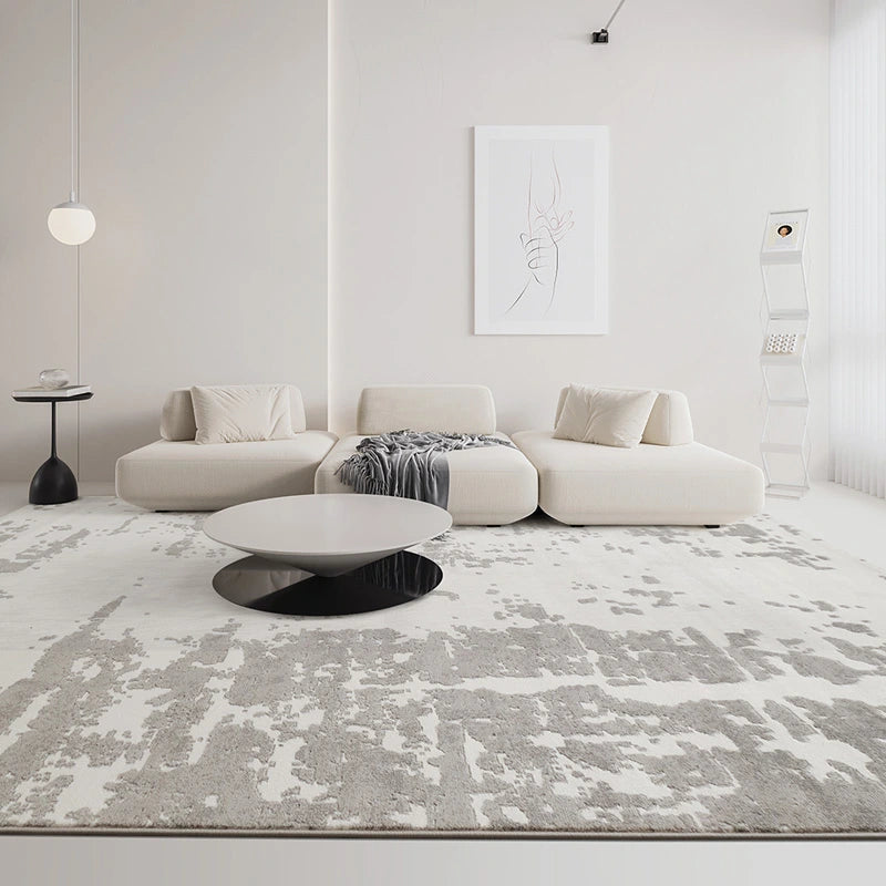 Modern abstract rug in a neutral-toned living room with minimalist furniture and a sleek coffee table #color_white