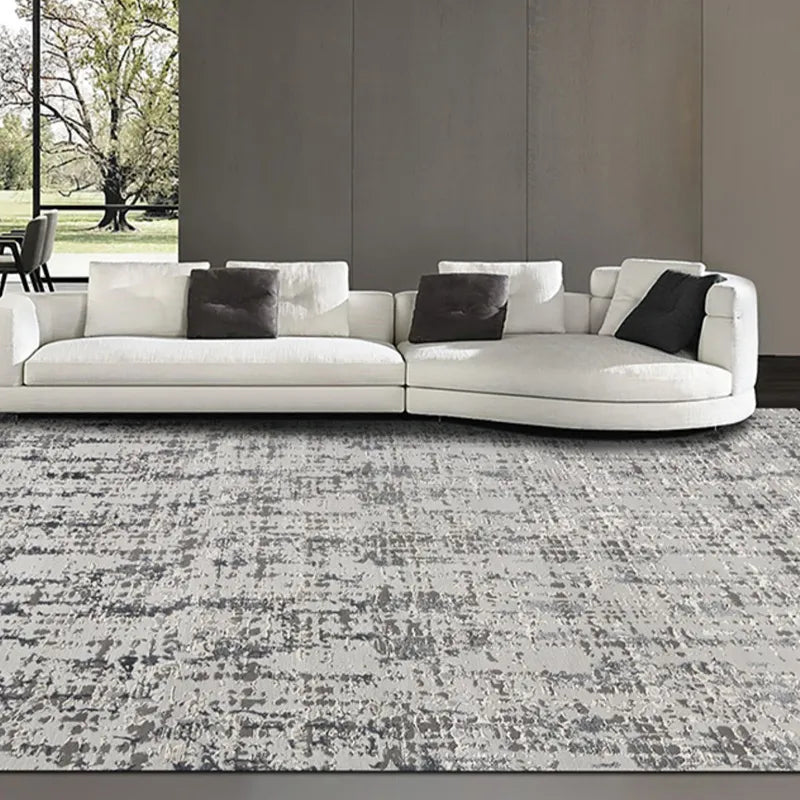 Modern grey patterned area rug in a minimalist living room with a white sectional sofa