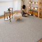 Natural wool blend rug in a bright living room with wooden furniture and soft lighting