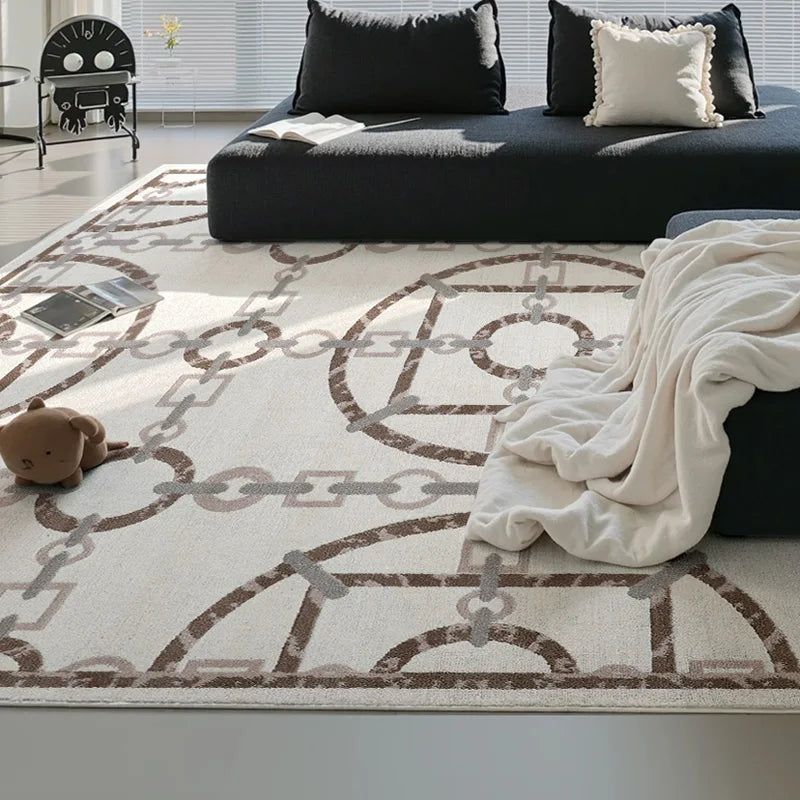 A minimalist modern living room with a cream chain-pattern rug and dark furniture, showcasing a clean and cozy design