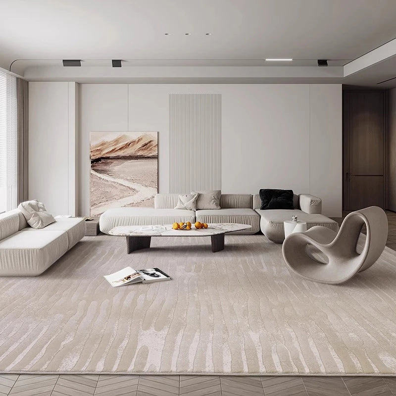 Modern minimalist living room interior featuring beige textured area rug, neutral sofa sets, abstract chair, and soft contemporary decor
