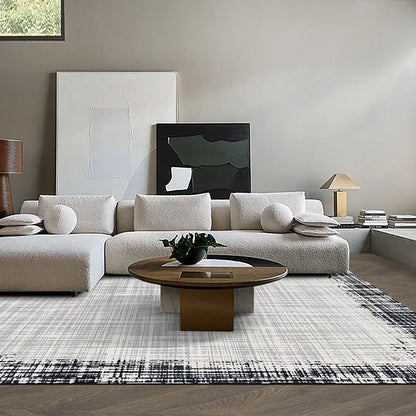 Modern living room with a soft white sofa and a neutral-toned rug featuring black border accents, creating a stylish and inviting atmosphere  