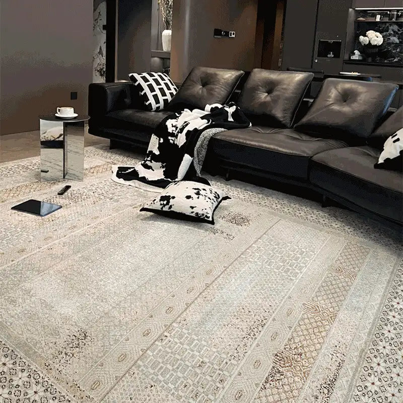 Vintage-inspired area rug in a modern living room with dark leather sofa and monochrome decor
