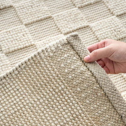 Natural ivory handwoven wool area rug corner detail showing the woven underside, hand-finished edge, and thick wool construction.