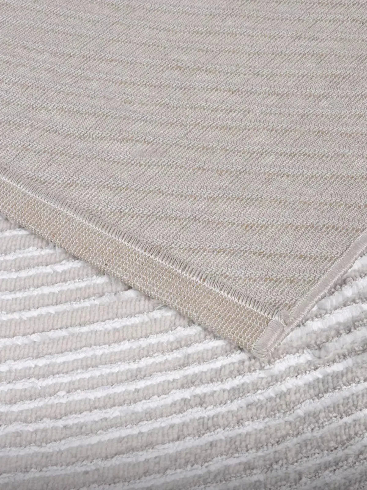 Close-up of a gray rug with natural jute backing and soft textured surface, highlighting durability and eco-friendly design