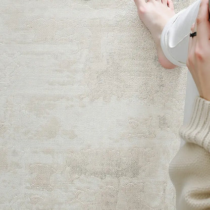 Close-up of a soft, abstract-patterned rug under relaxed feet, highlighting the plush texture and tranquil color palette perfect for modern calm interiors.