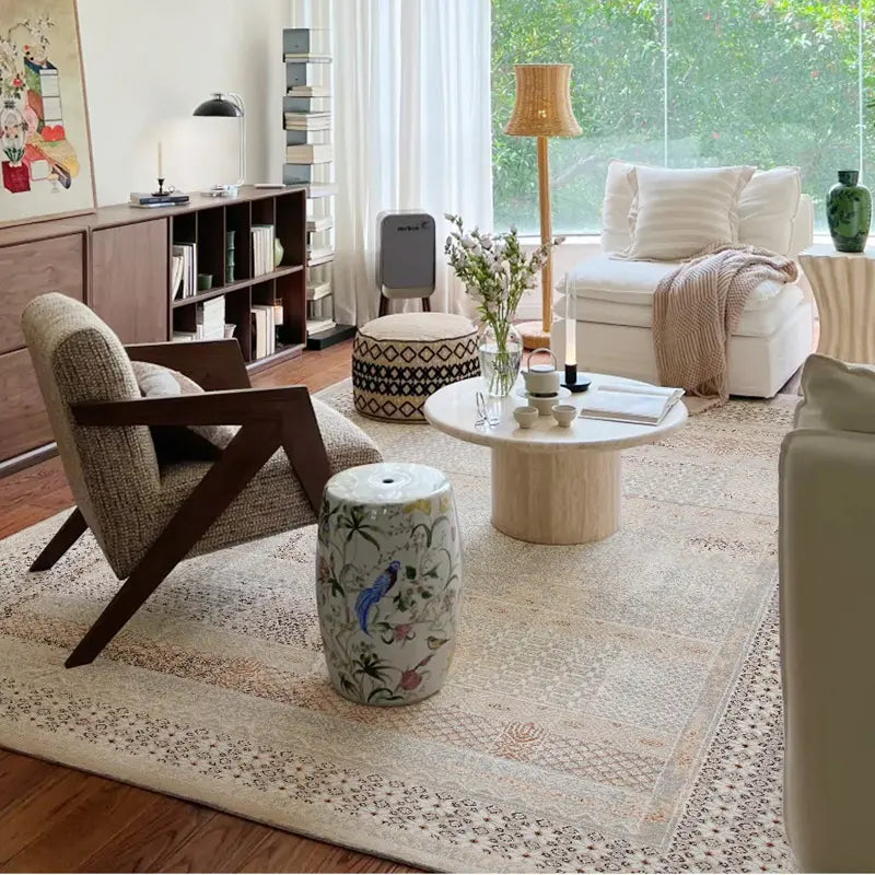 Neutral bohemian living room with vintage patterned area rug, natural wood furniture, and soft natural lighting