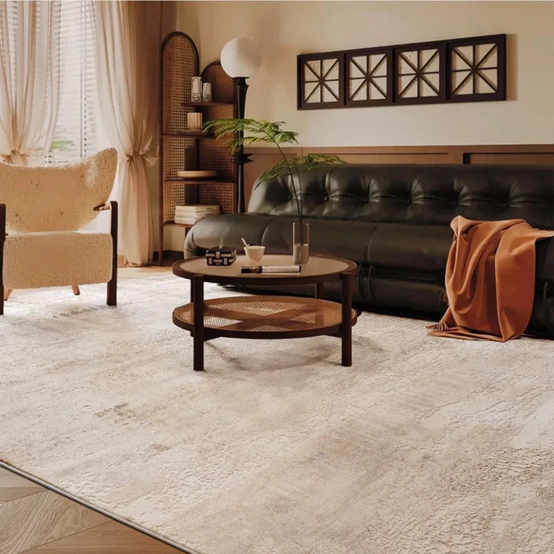 Neutral-tone area rug in a cozy living room with rattan furniture and a dark leather sofa