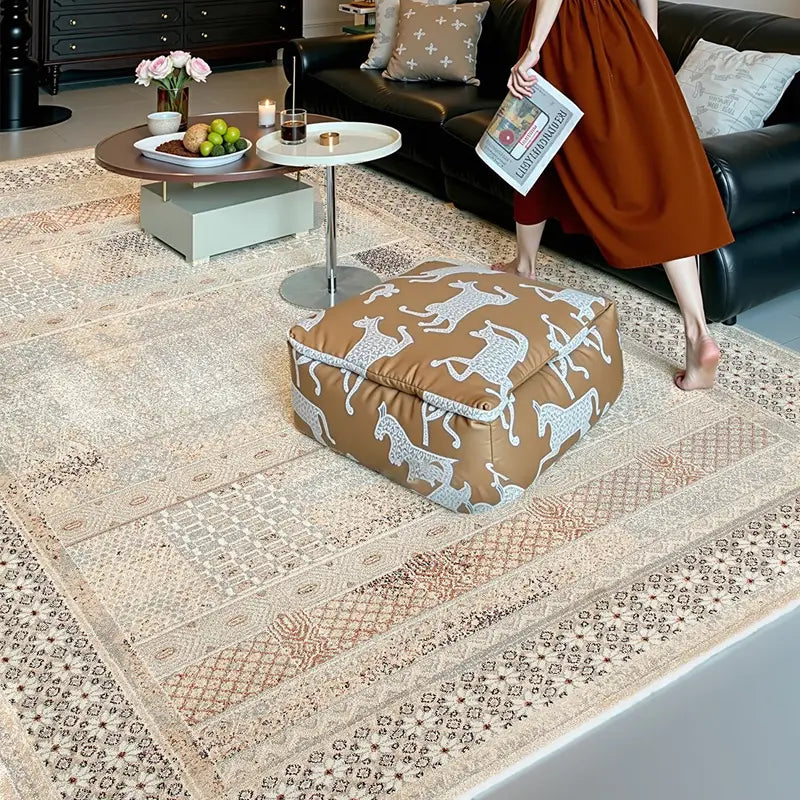 Patterned beige area rug in a cozy living room setup with footrest and modern round coffee tables