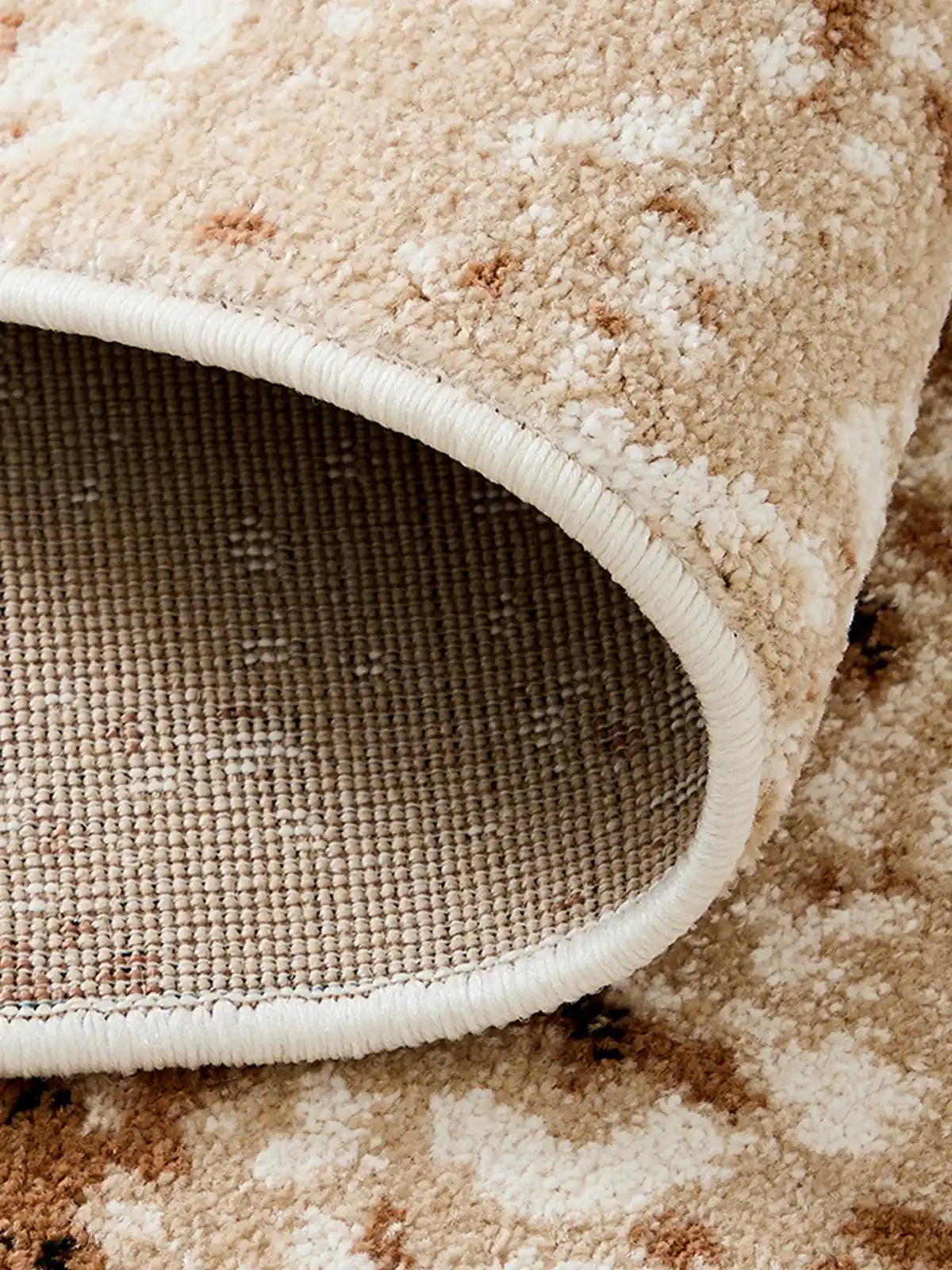 Close-up of rug backing and edge stitching showing non-slip woven base and thick pile texture