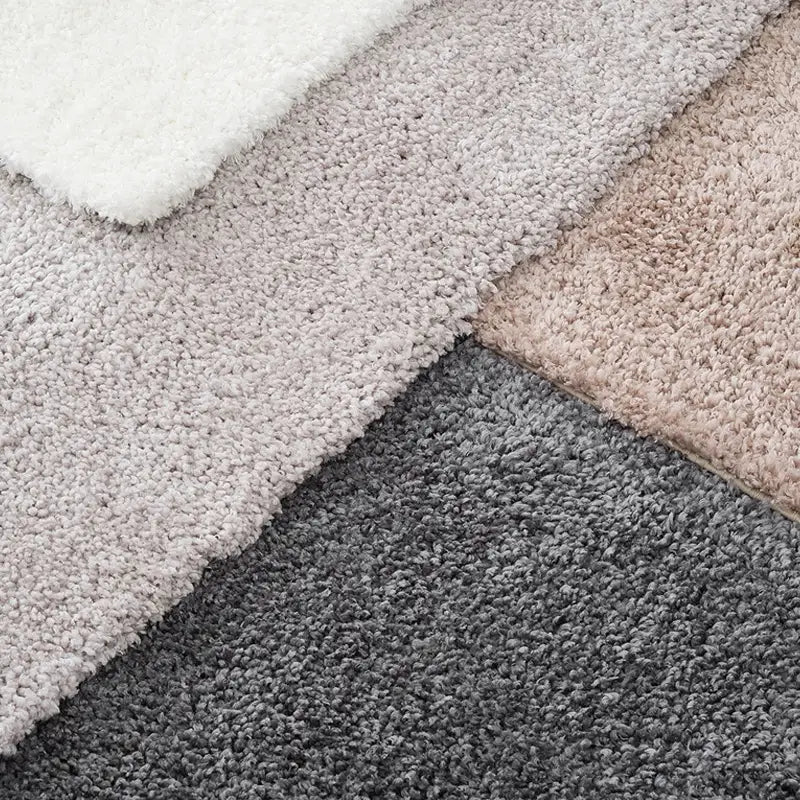 A collection of shaggy rugs in white, light beige, and dark gray tones, showcasing soft textures and modern elegance for versatile home styling 