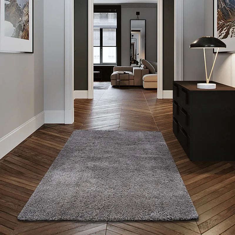 Gray shaggy rug placed in a modern hallway with wooden floors #color_Charcoal Gray