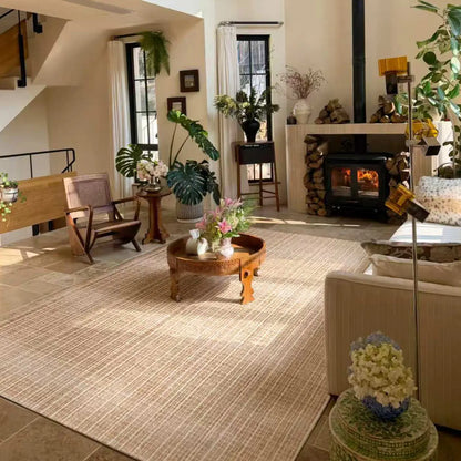 Warm beige Siena area rug in a sunlit living room with wood furniture and a fireplace