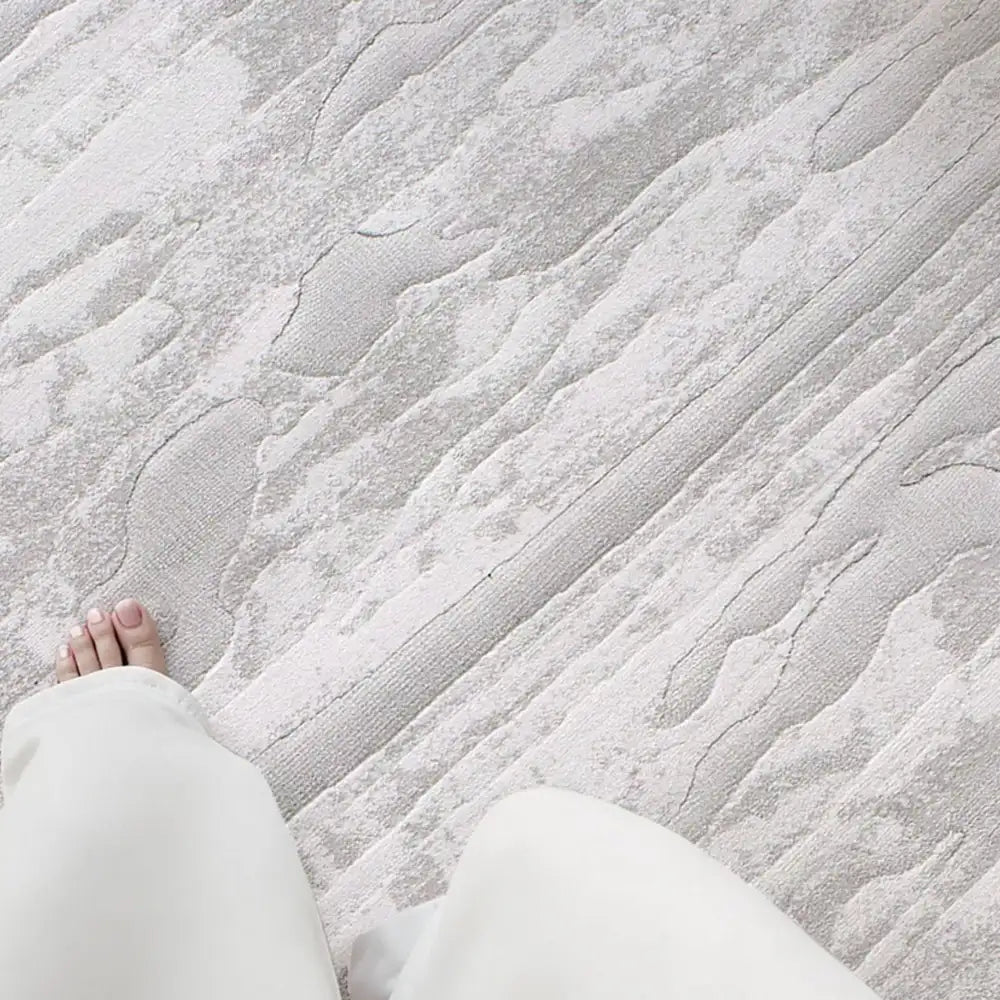 Barefoot standing on a thick gray textured rug, highlighting softness and underfoot comfort