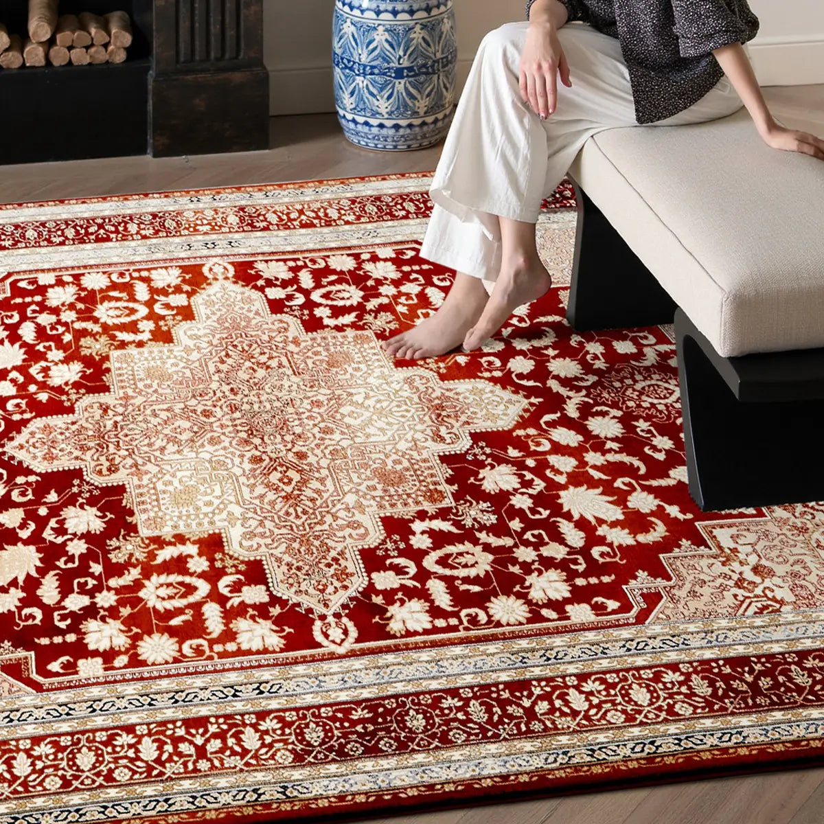 person sitting on sofa with feet on soft thick red Persian style rug