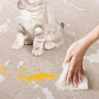 Taupe ivory abstract area rug with a cat nearby while a liquid spill is gently blotted for easy spot cleaning
