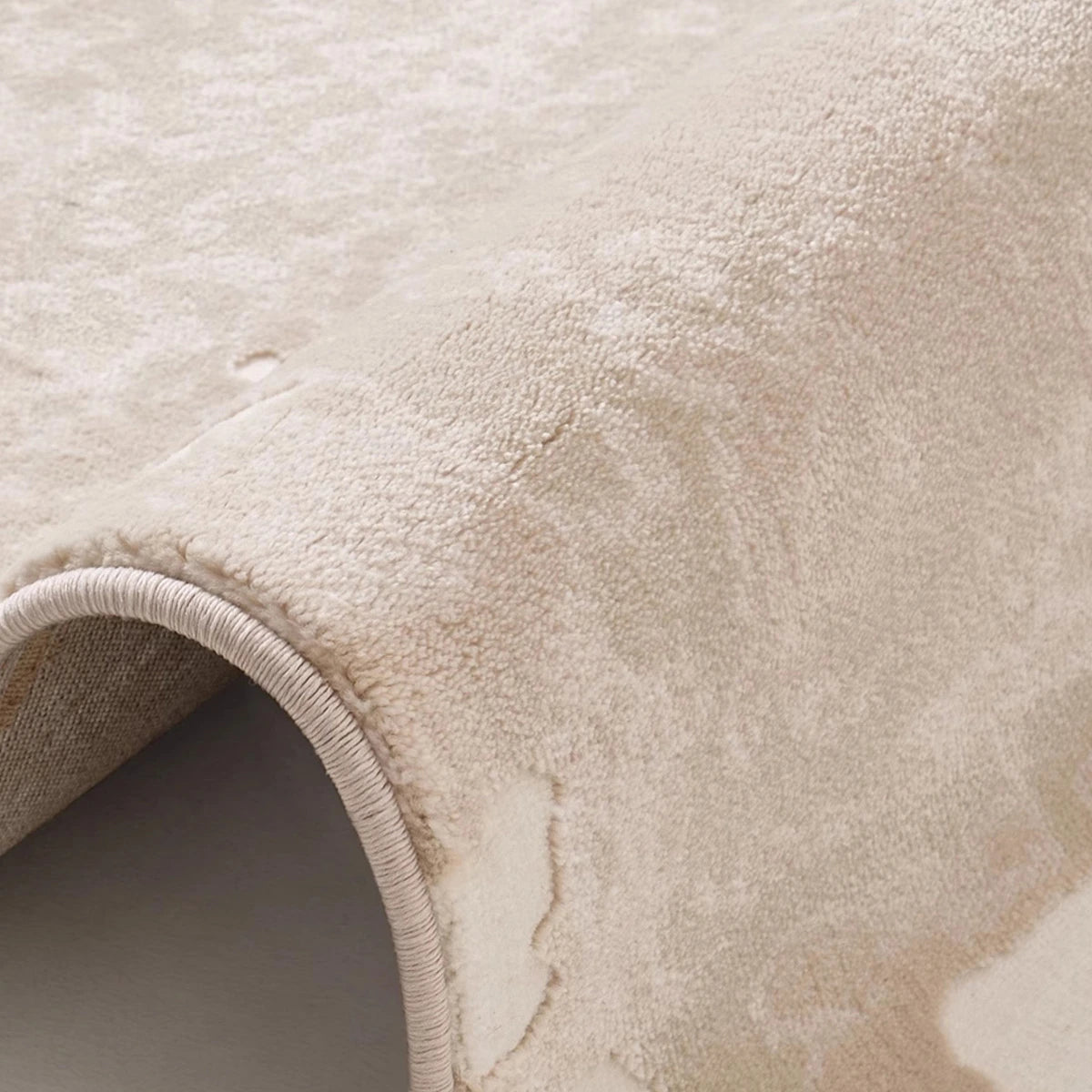 Taupe ivory abstract area rug close-up showing soft woven texture and subtle modern pattern