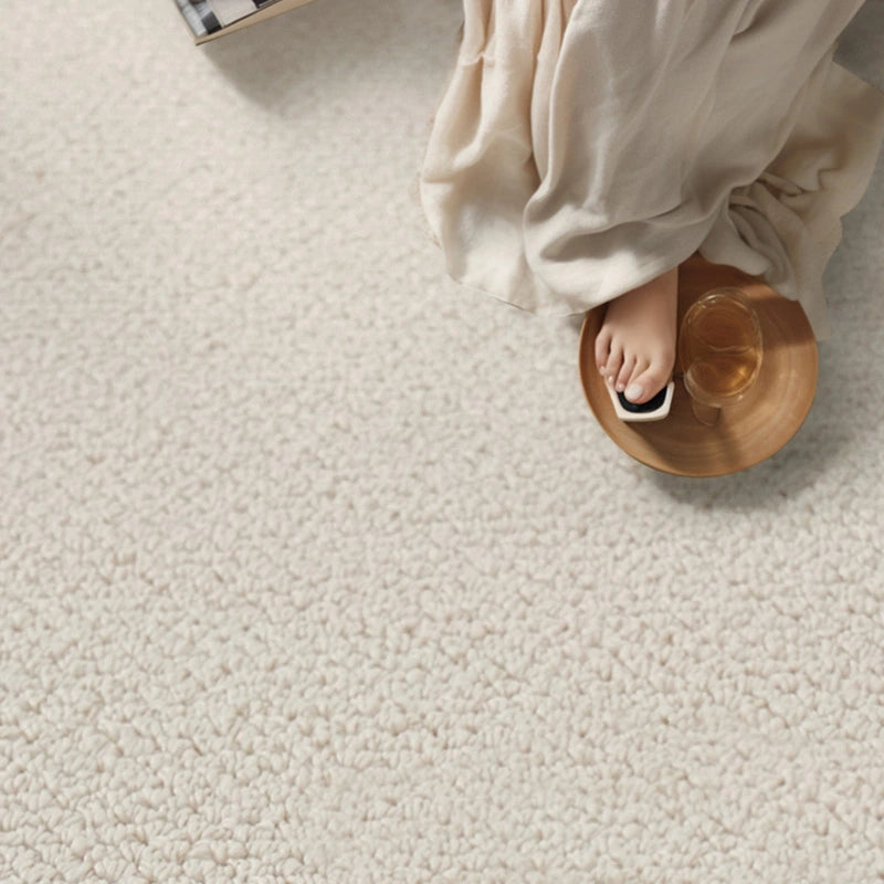 Close-up of soft loop-pile wool rug underfoot, highlighting plush texture and warmth in a serene reading corner