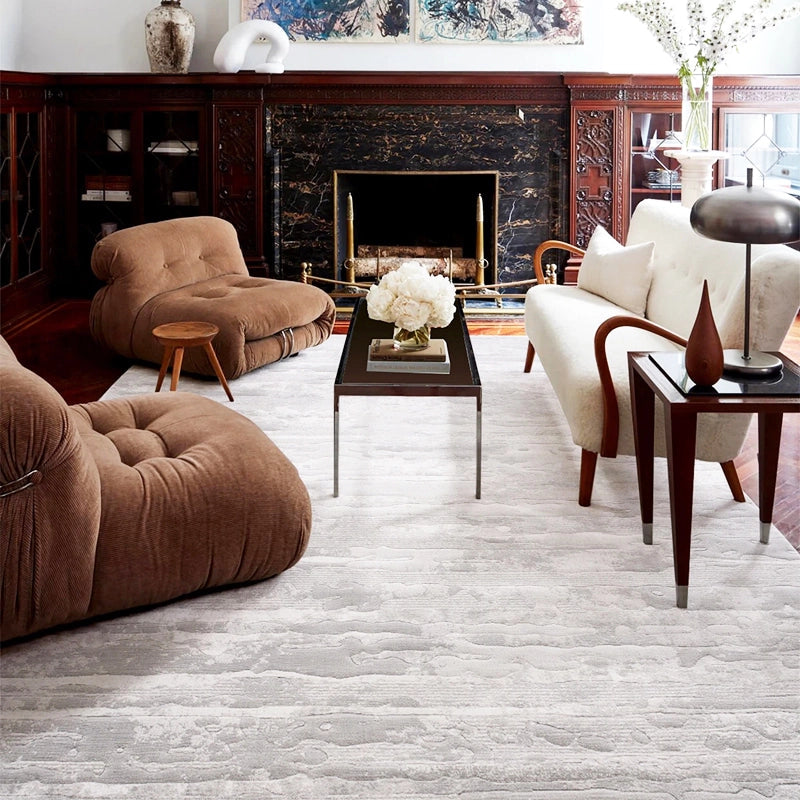 Textured gray rug in a classic living room with brown lounge chairs, a white sofa, and a fireplace #Texture_Linear Drift