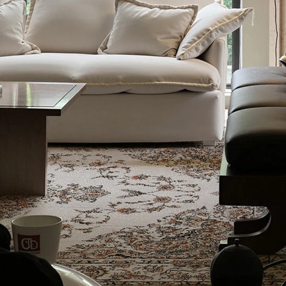 Vintage-inspired modern rug under cream sofa and dark wood coffee table in stylish living room