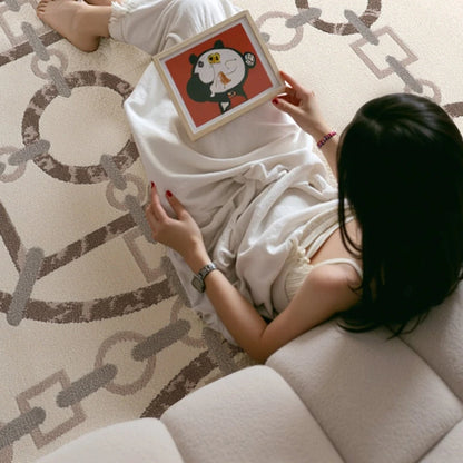Woman sitting on sofa, holding artwork, on a modern chain-pattern area rug