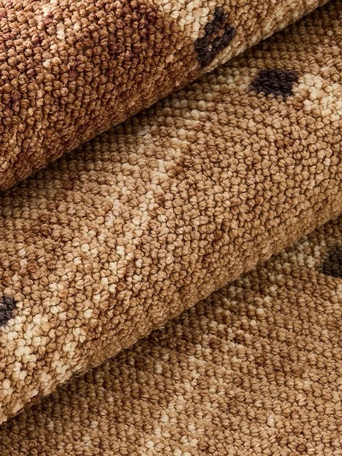 Close-up of wool blend area rug showing dense loop weave texture and warm neutral tones